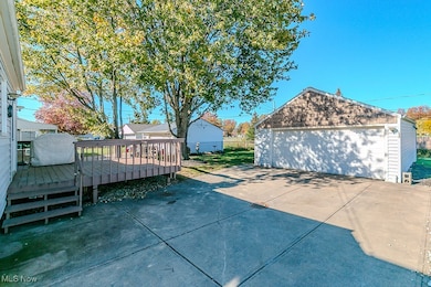 View of patio / terrace featuring an outbuilding, a wooden deck, and a detached garage
