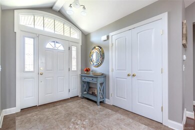 Elegant foyer with custom door,  ceramic floor and