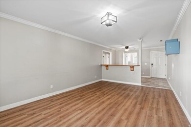 Empty room featuring crown molding, wood finished floors, and ceiling fan