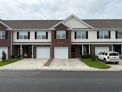 Townhome / multi-family property with driveway, an attached garage, and brick siding