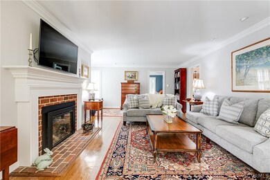 Living room with crown molding, wood-type flooring