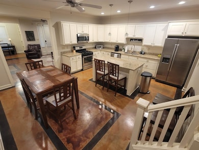 Kitchen featuring recessed lighting, white cabinetry, a ceiling fan, appliances with stainless steel finishes, and a sink