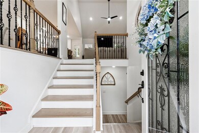Staircase with high vaulted ceiling, wood finished floors, and baseboards