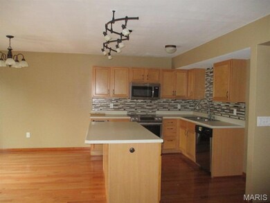 Kitchen with a chandelier, light countertops, appliances with stainless steel finishes, and dark wood-style floors