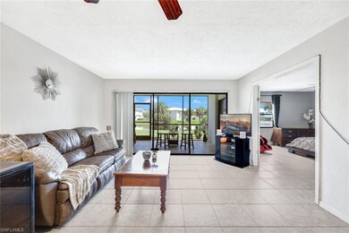 Tiled living room with ceiling fan and a textured ceiling