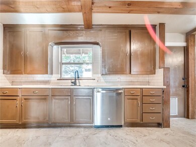Stepping into the kitchen you can see the stainless steel appliances, tons of cabinet and counter space, along with a window pointing to the backyard.