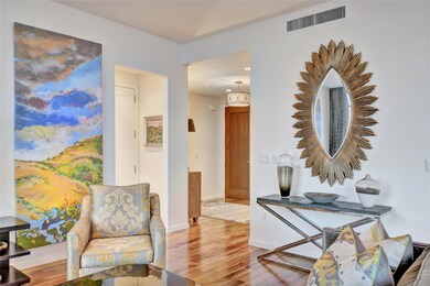 Hallway with visible vents, baseboards, and wood 