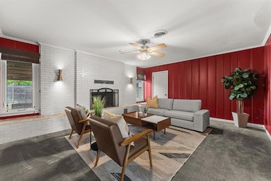 Carpeted living area with a fireplace, ceiling fa