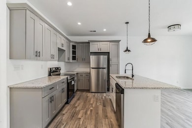 Kitchen with pendant lighting, sink, appliances wi