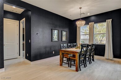 Dining area with a textured wall, baseboards, ligh