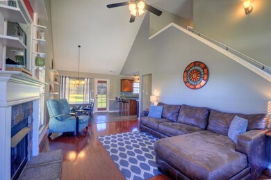 The living room has fresh paint, vaulted ceilings, a gas fireplace complemented with gorgeous stonework, beautiful hardwood floors, and tons of natural light pouring into the room.