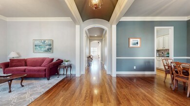 Enter into the home to hardwood floors, a barrel-vaulted ceiling, and crown molding. To the left is a formal living room, however, it can be used as an office or converted to a 6th bedroom (3rd on main level). To the right, is the formal dining room.