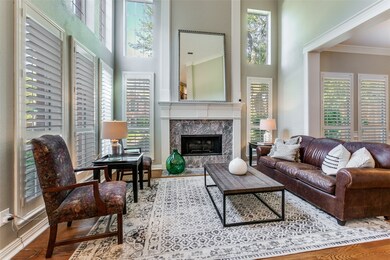 Living area with crown molding, wood floors, an abundance of natural light and beautiful plantation shutters