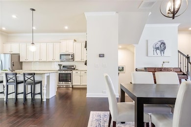 Dining room featuring crown molding, dark wood-type flooring, a chandelier, baseboards, and recessed lighting