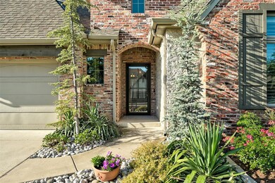 View of exterior entry featuring brick siding and a garage