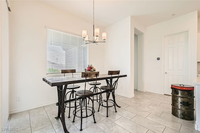 Dining room featuring a chandelier, light tile pat