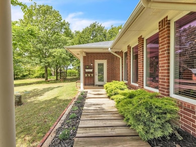 Doorway to property with brick siding, a yard, and