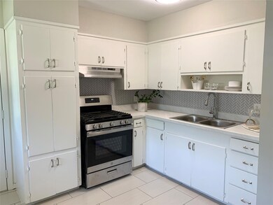 Kitchen with white cabinetry, sink, tasteful backs