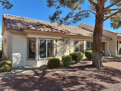 Rear view of property with stucco siding and a til