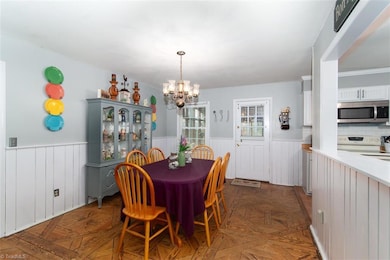 View of Dining area shows open Kitchen area to the right and exterior door leads to fabulous screened porch addition.
