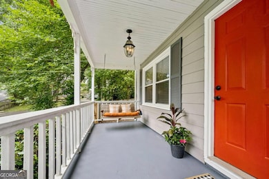 This storybook front porch, complete with a charming porch swing, sets the tone for the home's warm and welcoming vibe.