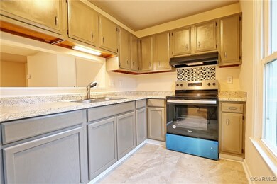 Kitchen with stainless steel range with electric cooktop and sink