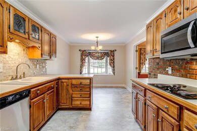 The breakfast room and kitchen sit adjacent to the dining room. Breakfast room is a great spot for casual dining and features a bay window.  Note the tile backsplash and double sink.