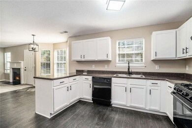 Kitchen featuring black appliances, dark hardwood 
