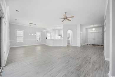 Unfurnished living room featuring ceiling fan, bas
