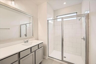Bathroom featuring a shower stall and vanity
