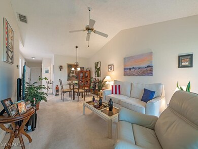 Living room featuring vaulted ceiling, light color