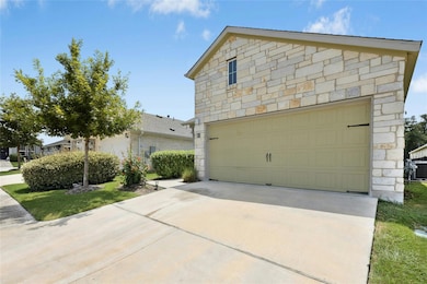 View of front of home with stone siding, driveway, and a garage