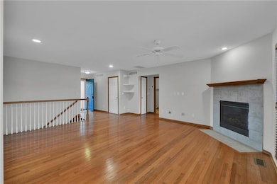 Unfurnished living room featuring recessed lighting, light wood-style flooring, a fireplace, and a ceiling fan