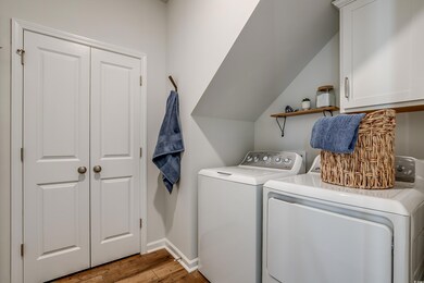 Washroom with cabinets, washer and dryer, and ligh