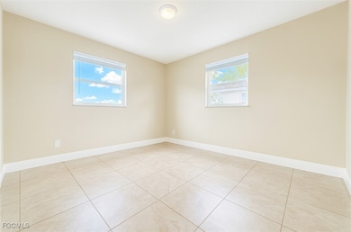 Spare room with baseboards and light tile patterned floors