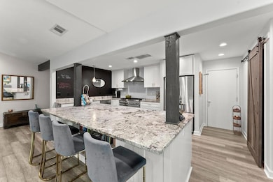 Kitchen featuring wall chimney range hood, applian
