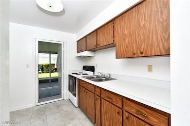 Kitchen featuring white electric range oven, a sin