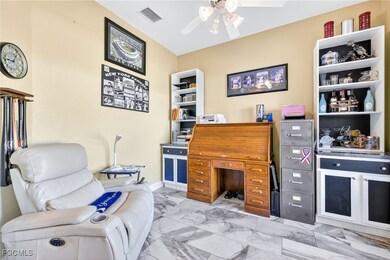 Office with a ceiling fan and marble finish floori