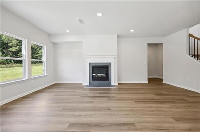 Unfurnished living room with stairway, a fireplace with flush hearth, light wood finished floors, and recessed lighting