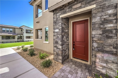 Entrance to property featuring stone siding and st
