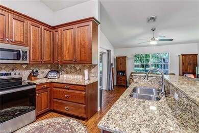 Kitchen with ceiling fan, vaulted ceiling, backspl
