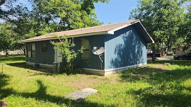 View of side of property featuring a central air condition unit and a lawn