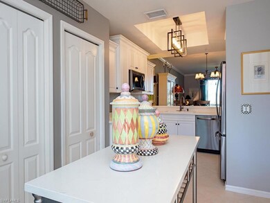 Kitchen featuring decorative light fixtures, white cabinetry, a chandelier, stainless steel appliances, and light tile patterned floors