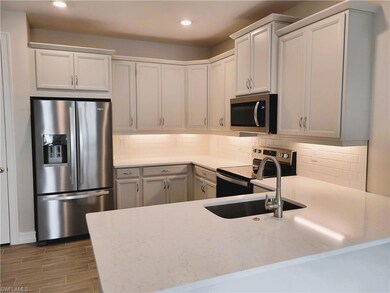 Kitchen featuring tasteful backsplash, light stone