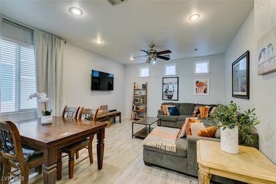Living area featuring a ceiling fan, light wood-st