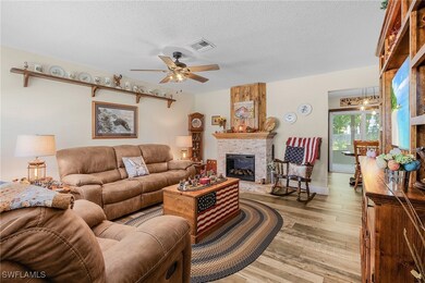 Living area with a large fireplace, visible vents,
