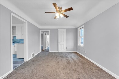 Carpeted spare room featuring ceiling fan