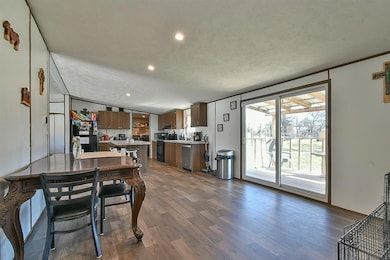 Dining room featuring dark wood-type flooring, a textured ceiling, and recessed lighting