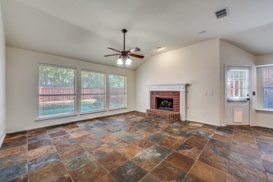 Unfurnished living room with lofted ceiling, a fireplace, a ceiling fan, and stone tile floors