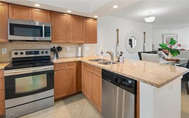Kitchen featuring tasteful backsplash, appliances with stainless steel finishes, sink, and kitchen peninsula